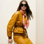 Mlle Ceinté Paris silk scarf, antique gold tankard, fresh orange, yellow striped fabric drape, wooden scrolls, salmon pink background still life.