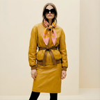 Mlle Ceinté Paris silk scarf, antique gold tankard, fresh orange, yellow striped fabric drape, wooden scrolls, salmon pink background still life.