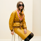 Mlle Ceinté Paris silk scarf, antique gold tankard, fresh orange, yellow striped fabric drape, wooden scrolls, salmon pink background still life.